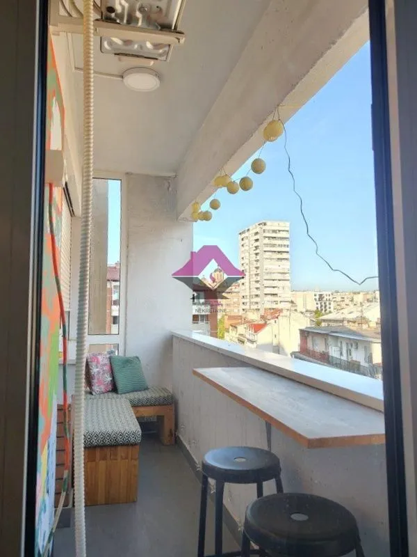 Furnished balcony area with seating and city view.