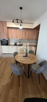 Trpezarija sa okruglim stolom i modernim stolicama u sklopu kuhinje. - image 3
