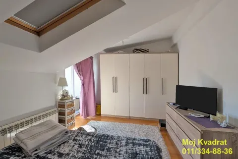 Attic bedroom with a bed, large wardrobe, and skylight window. - image 11