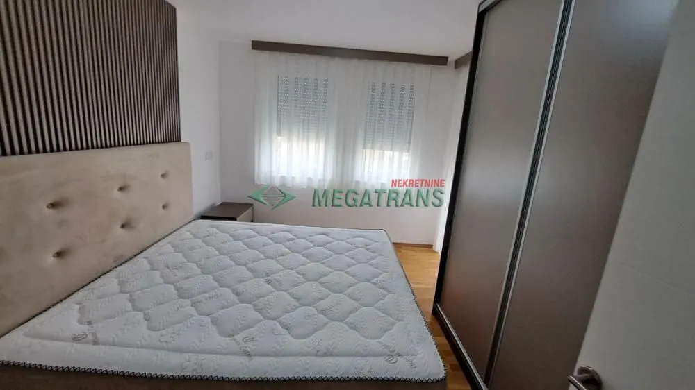 Spavaća soba sa bračnim krevetom, uzglavljem i velikim garderoberom.