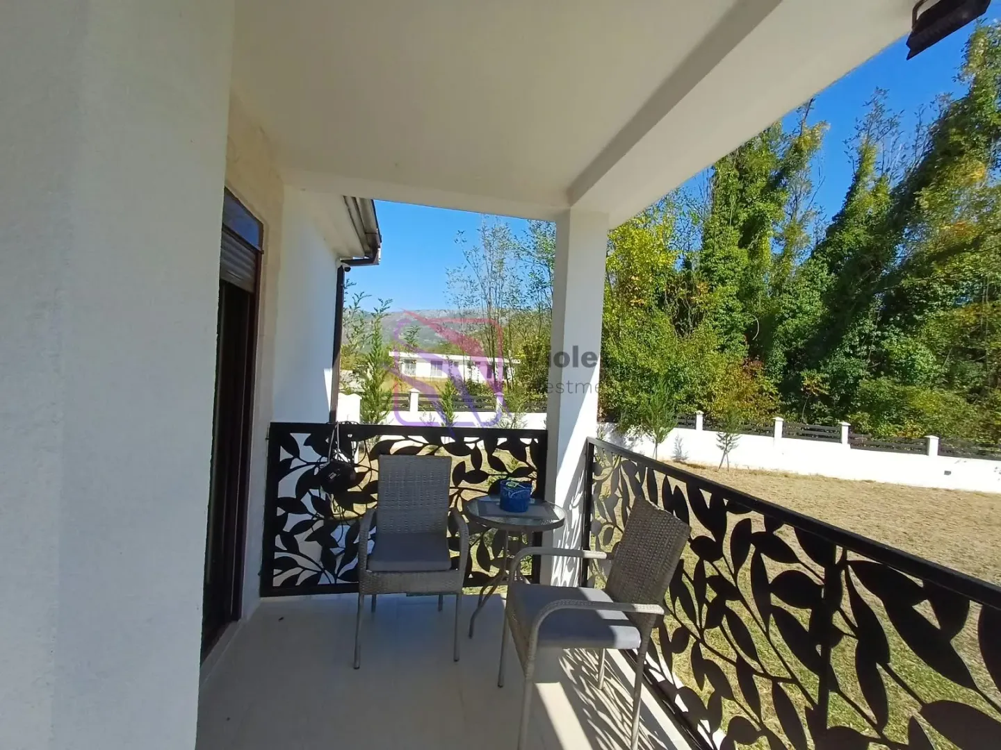 Covered terrace with patio furniture and a view of the yard.