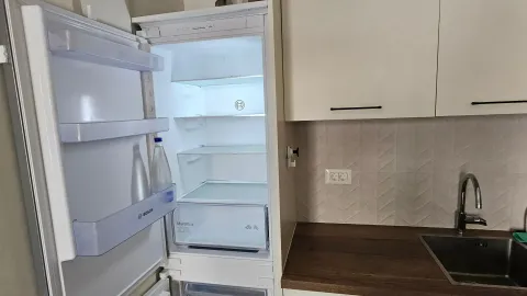 Pogled na dio kuhinje sa otvorenim frižiderom i sudoperom. - image 9