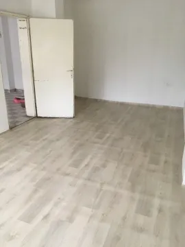 Empty room with laminate flooring and white walls. - image 12