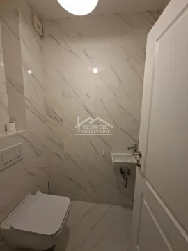 Smaller bathroom tiled with marble-patterned ceramic tiles. - image 10