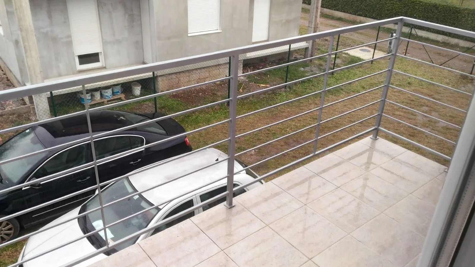 A tiled balcony with a metal railing.