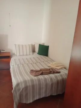 Manja spavaća soba sa krevetom i noćnim stočićem. - image 2