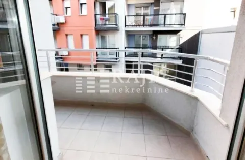 Small tiled balcony with metal railing and a view of the building. - image 5