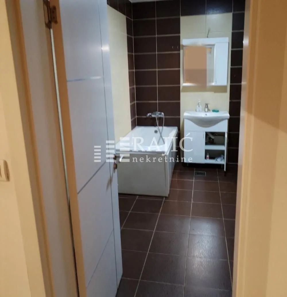 View of the bathroom with a bathtub and sink.