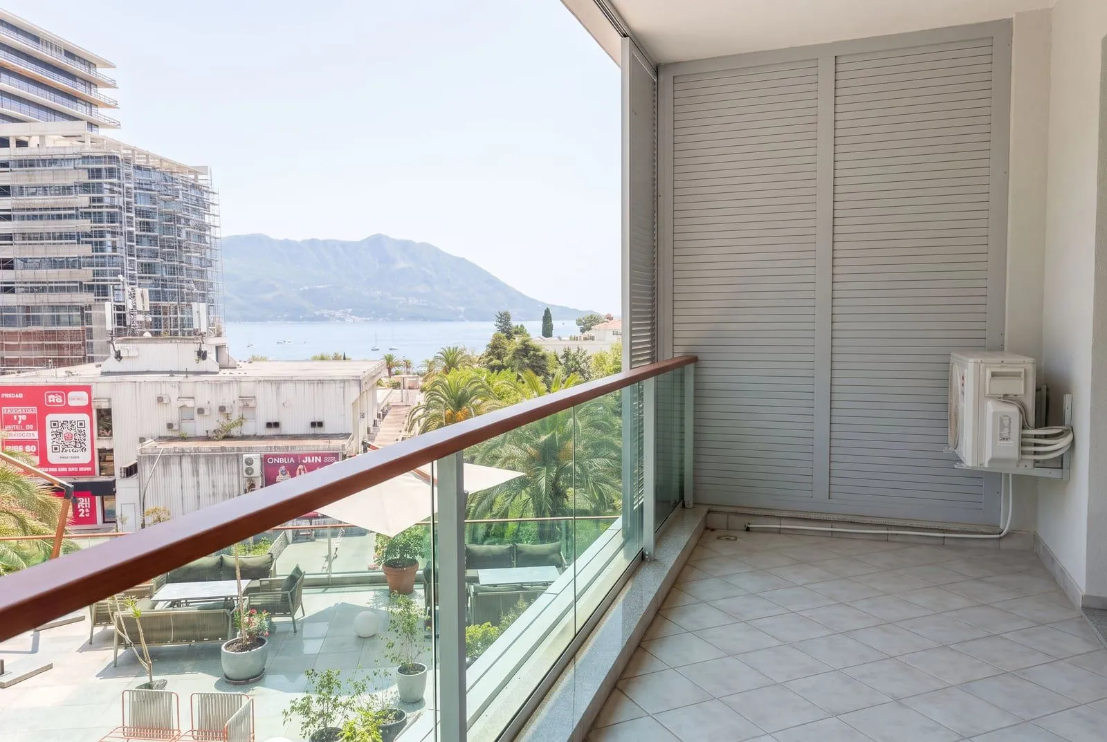 Spacious balcony with a view of the sea and surroundings.