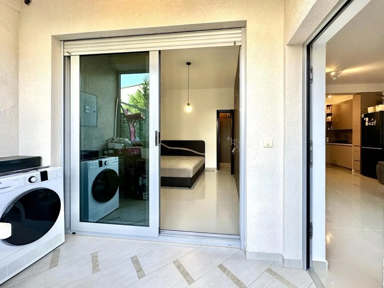 Terasa sa mašinom za veš i pogledom na unutrašnjost apartmana.