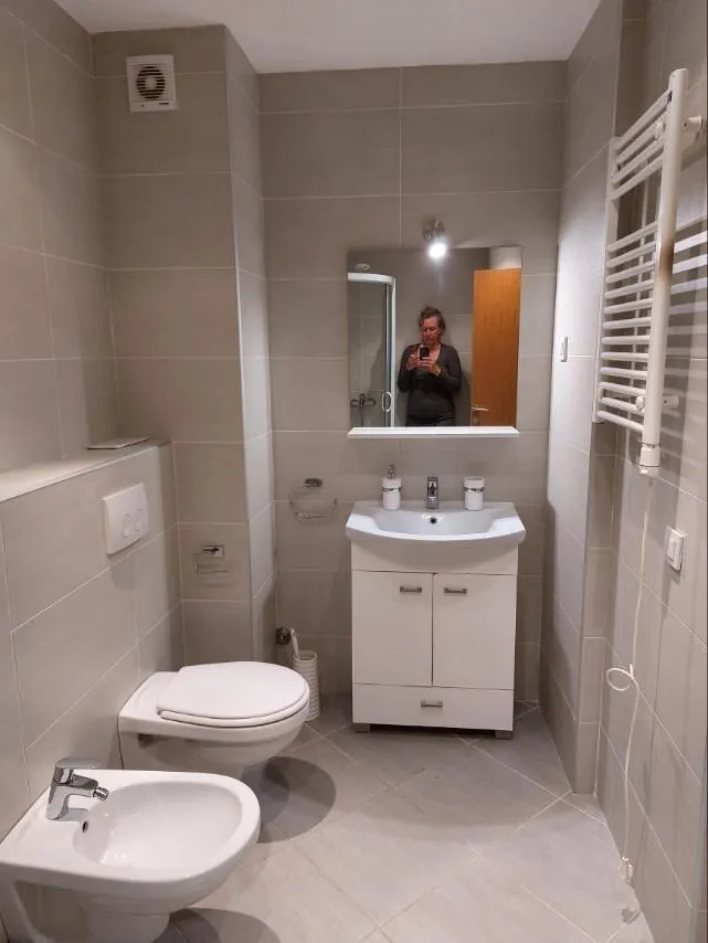Svijetlo kupatilo sa bideom, toaletnom šoljom i lavaboom.