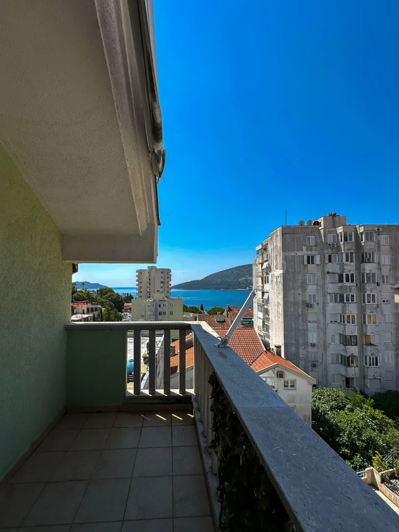 Pogled na more i okolne zgrade sa balkona.