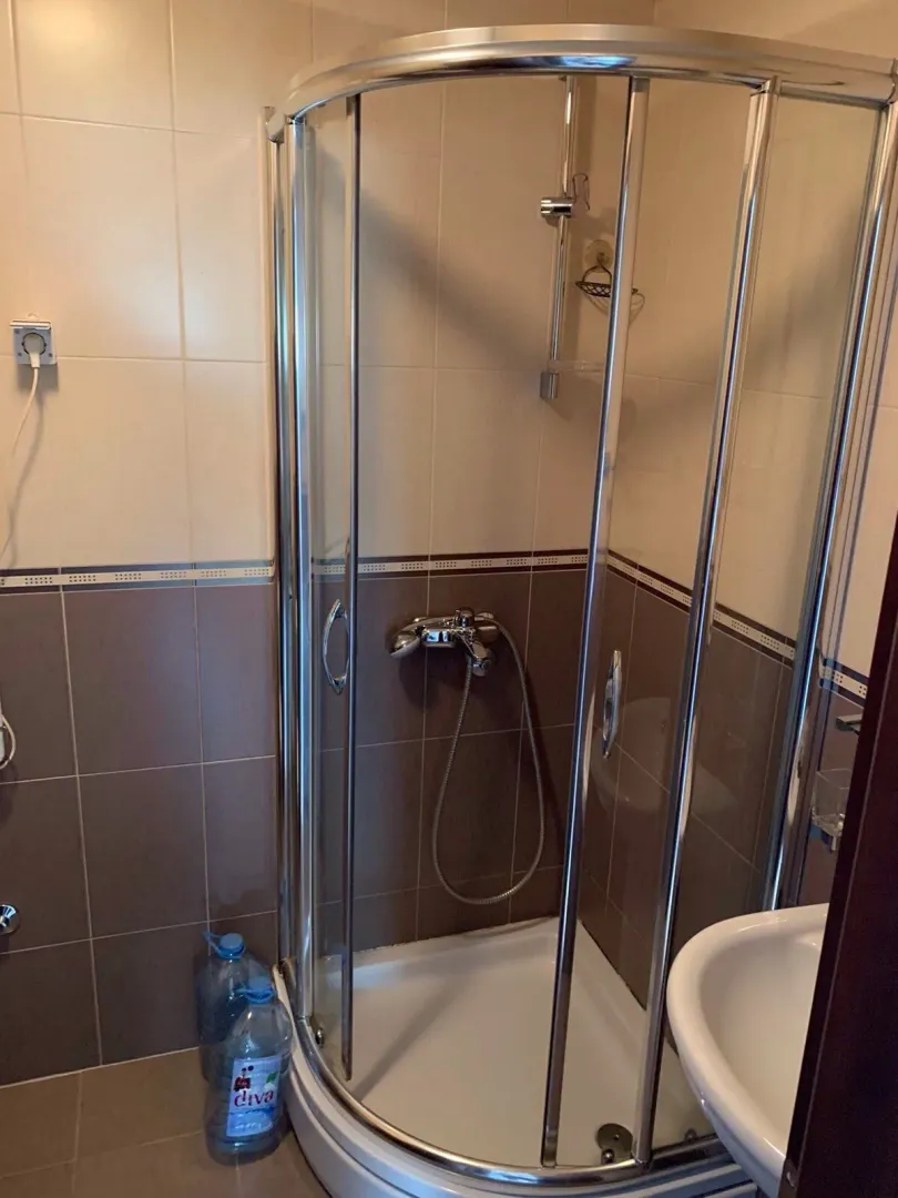 Kupatilo sa tuš kabinom i keramičkim pločicama.