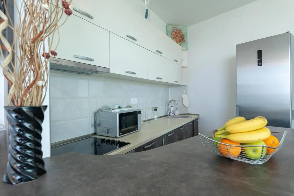 Modern kitchen with white cabinetry, built-in appliances, and a countertop.