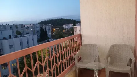 Balcony with chairs and city view. - image 12