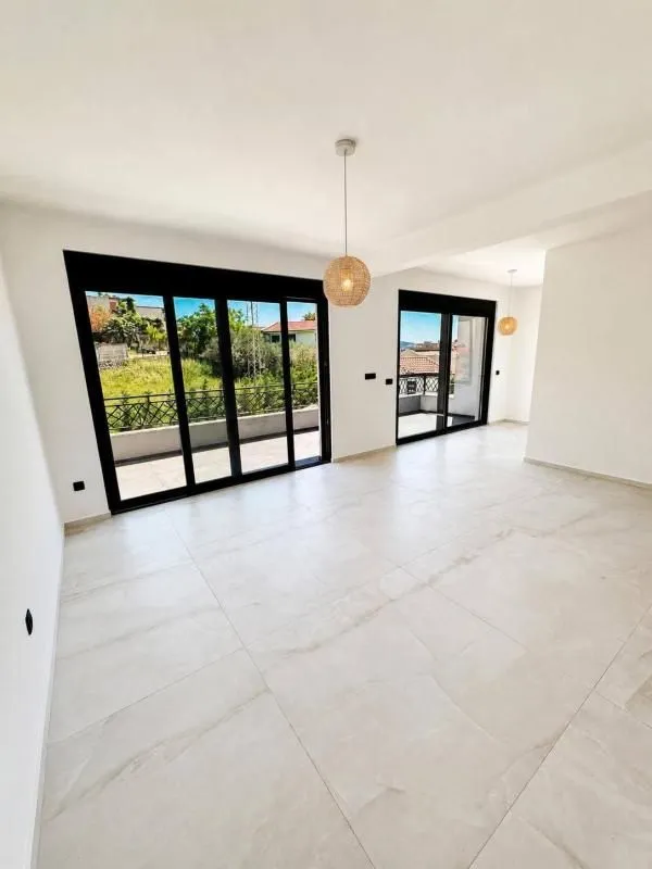Spacious living room with large glass surfaces and exterior view.