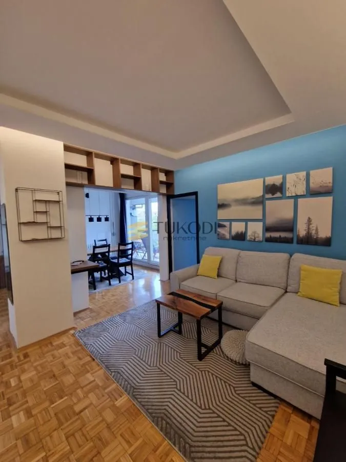 Living room with a sectional sofa, coffee table, and a view of the dining area.