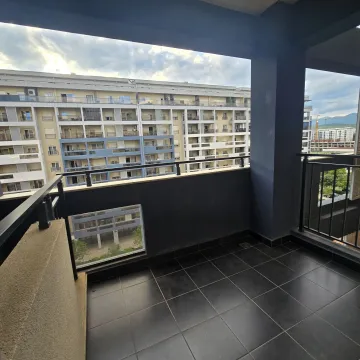 Spacious covered balcony with dark tiles and a view of surrounding buildings. - image 6