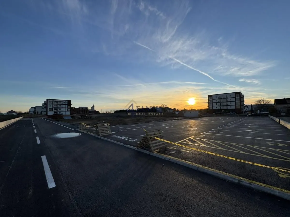 Pogled na parking i okolne stambene zgrade u izgradnji tokom zalaska sunca.