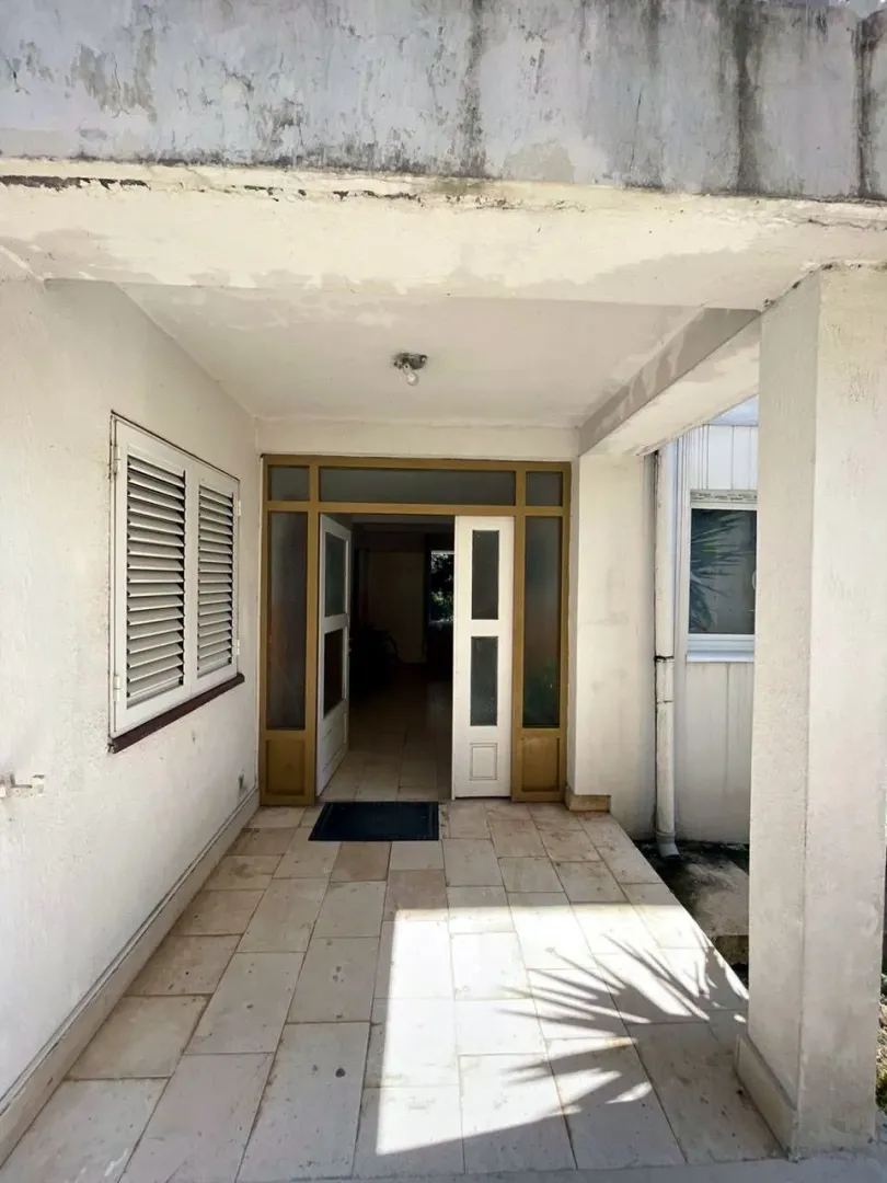 Main entrance to the house with a covered porch and open double doors.