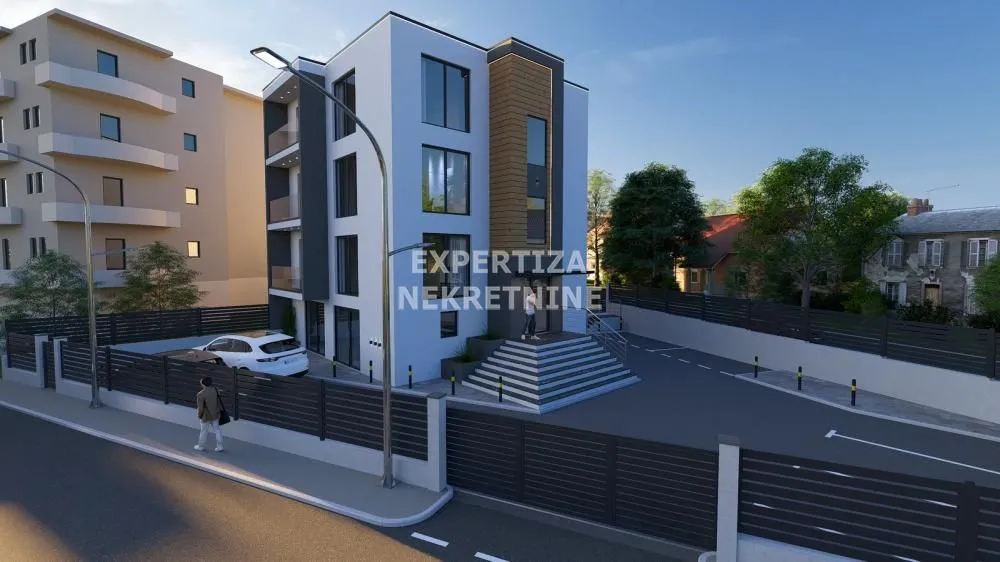 Exterior view of a modern residential building with a courtyard and parking.