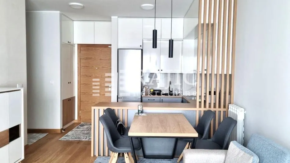 Modern living room interior with a dining area and kitchen in the background.