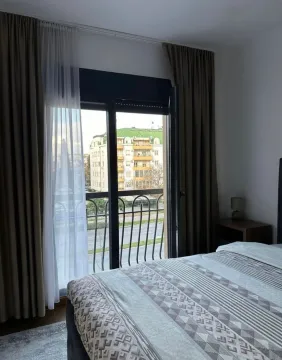 Namještena spavaća soba sa bračnim krevetom i izlazom na balkonska vrata. - image 13