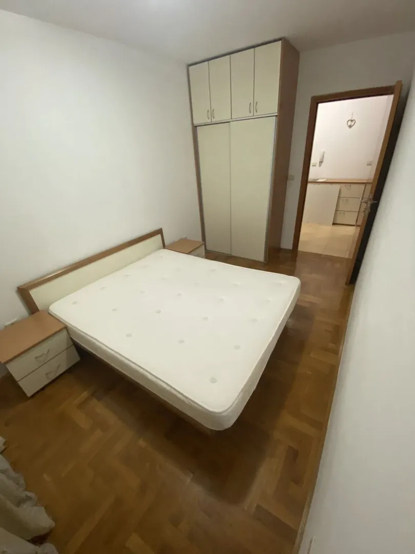 Bright bedroom with a double bed, nightstands, and a built-in wardrobe.