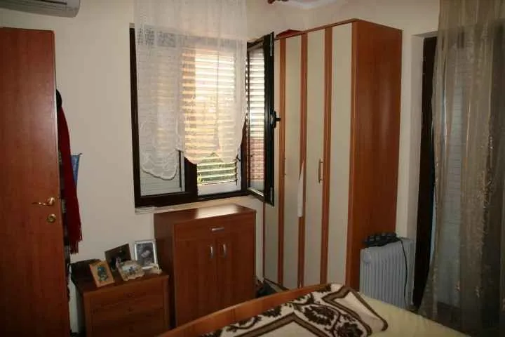 Namještena spavaća soba sa drvenim namještajem.