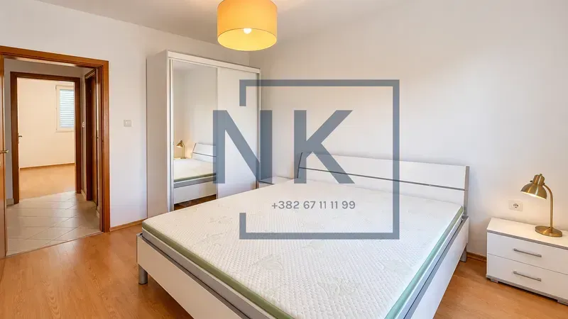 Furnished bedroom with a double bed, wardrobe, and nightstand.