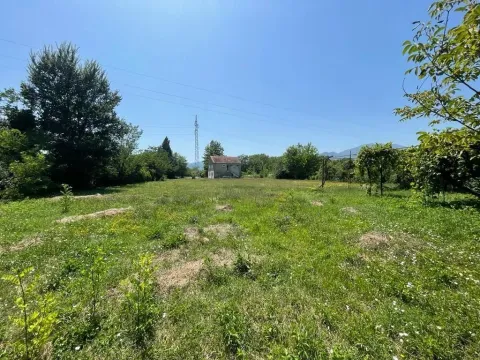 Prostrana zelena livada sa kućom u pozadini pod vedrim nebom. - image 5