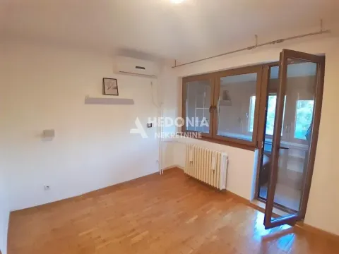 Prazna soba sa drvenim podom, klima uređajem i izlazom na terasu. - image 6