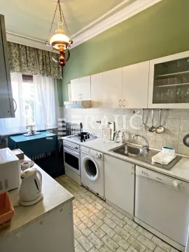 Small kitchen with white cabinets, sink, and built-in appliances. - image 4