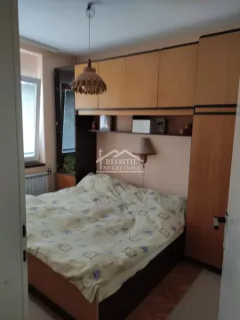 Nameštena spavaća soba sa bračnim krevetom i ugrađenim drvenim ormarima. - image 6