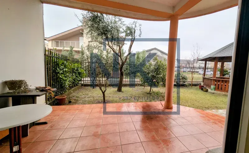 Covered terrace with tiled flooring and a view of the landscaped yard.