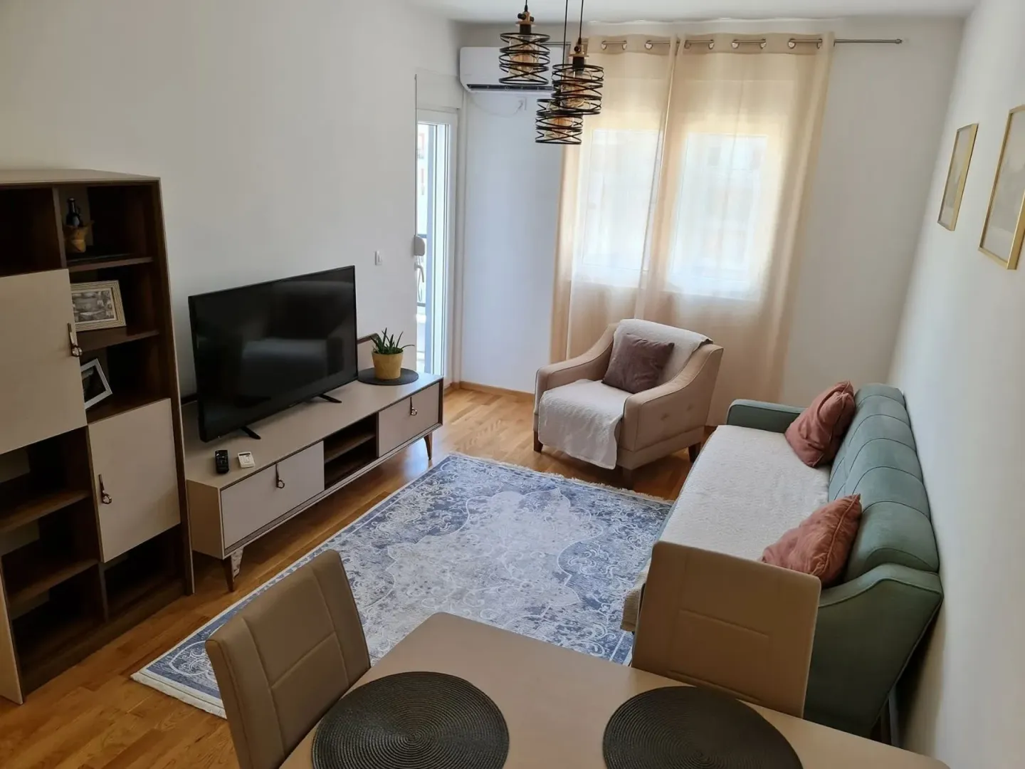 Bright living room with a sofa, armchair, and dining table.