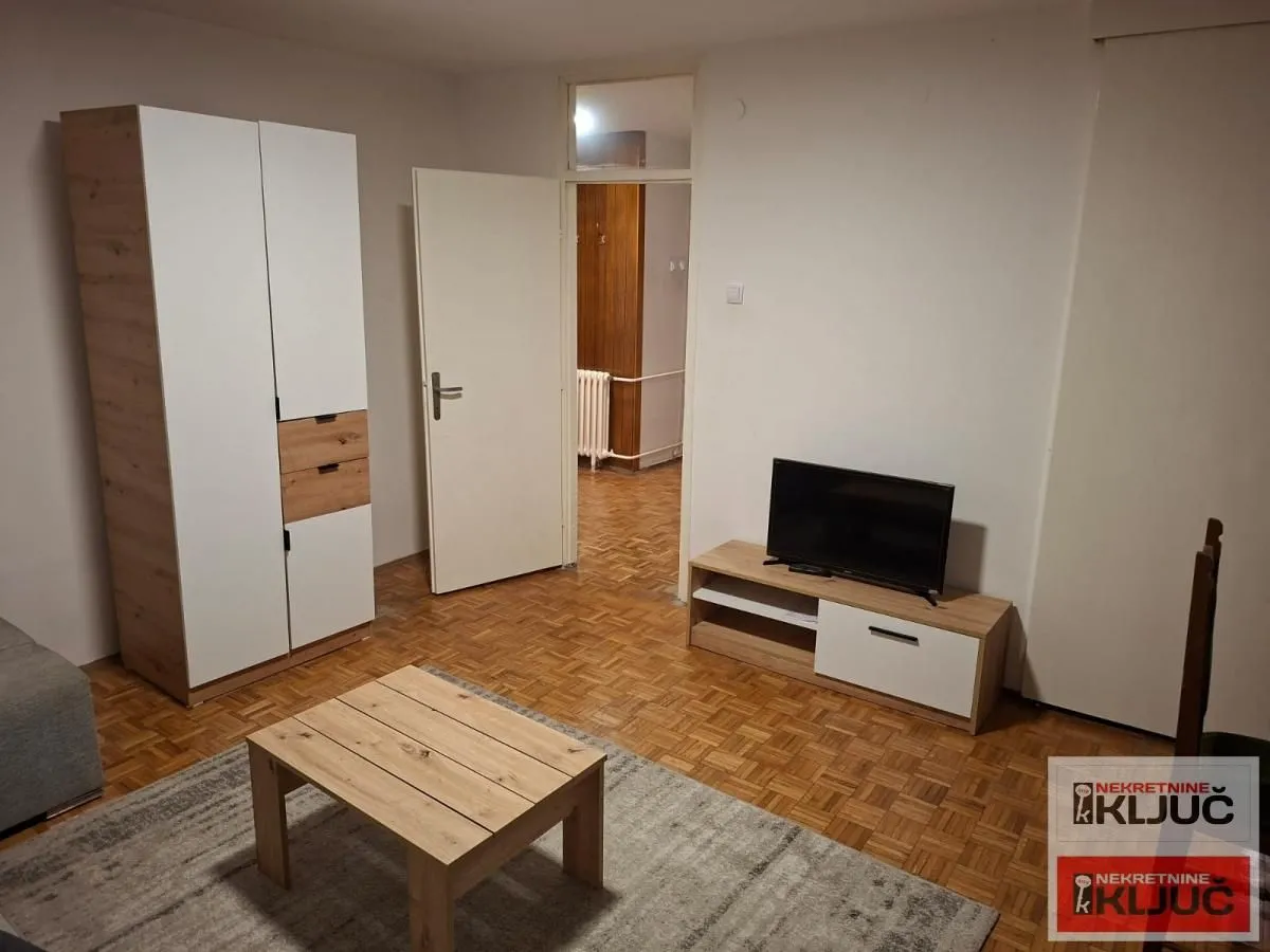 Dnevna soba sa garniturom, TV komodom i ormanom.
