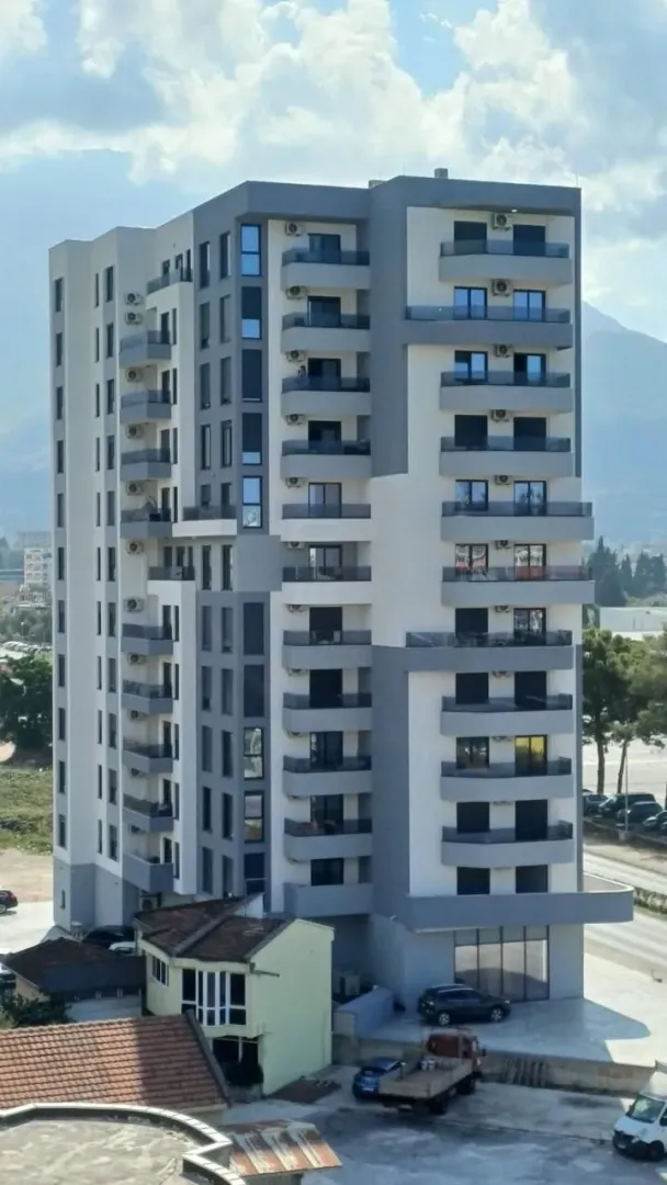 Pogled na spoljašnjost moderne višestambene zgrade sa terasama.