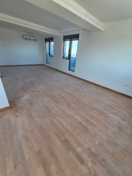 Prazna neopremljena prostorija sa parketom i belim zidovima. - image 3