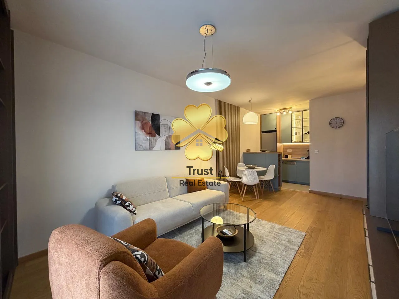 Modern living room with a sofa and dining area in the background.