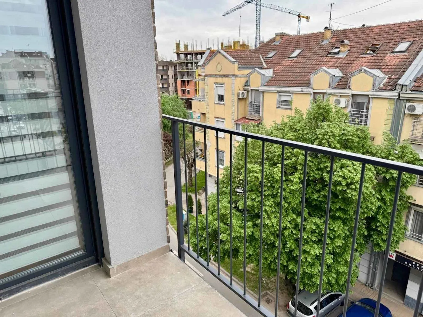 Pogled sa balkona na okolne zgrade i gradsko naselje.