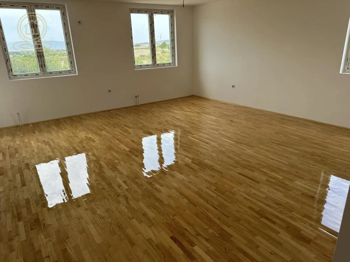 Empty room with parquet flooring and white walls.