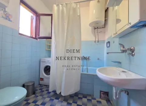 Manje kupatilo sa plavim pločicama, kadom i veš mašinom. - image 9