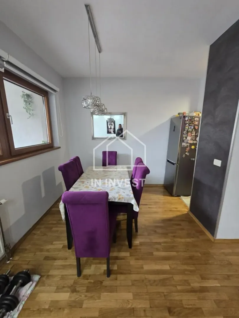 Trpezarija sa stolom i ljubičastim stolicama.