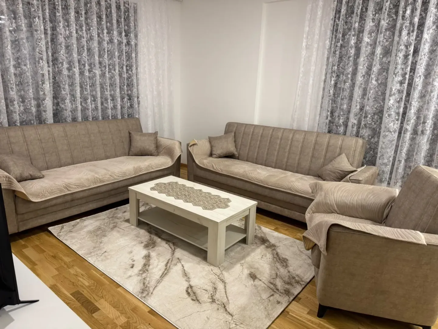 Living room with a sofa set, coffee table, and rug.