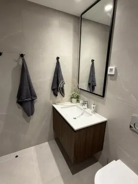 Modern bathroom with a vanity, mirror, and grey tiles. - image 8