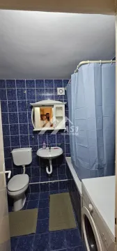 Kupatilo obloženo plavim pločicama sa kadom, umivaonikom, WC šoljom i veš mašinom. - image 11