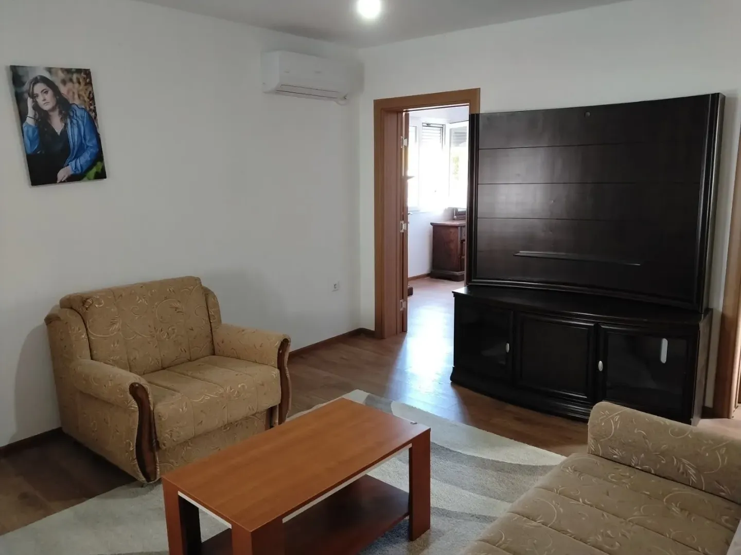 Living room with a sofa set, coffee table, and TV unit.