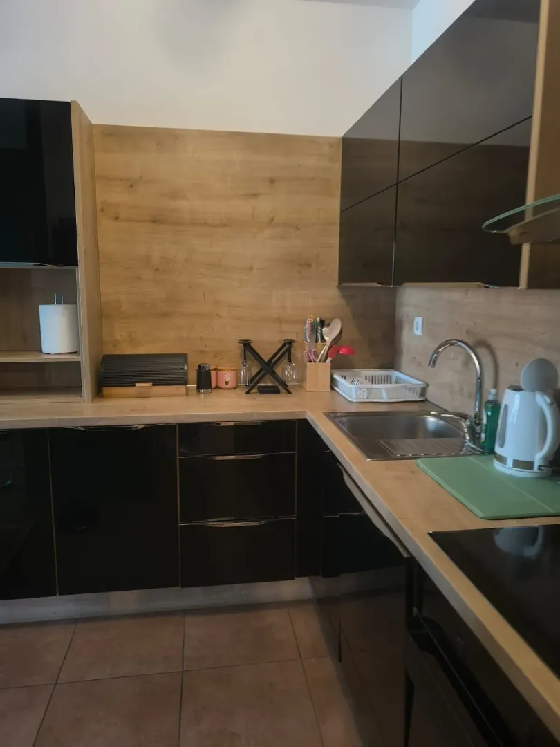 Modern kitchen with dark cabinets and wood details.