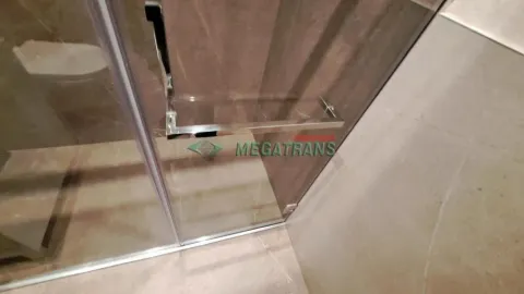 Detalj tuš kabine sa staklenim paravanom i keramičkim pločicama u kupatilu. - image 6